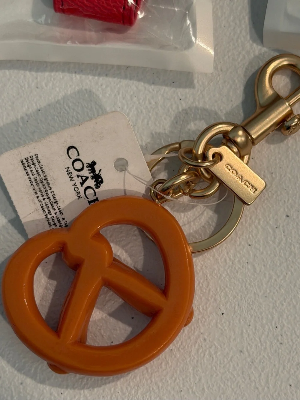 COACH Gold-Tone Key Ring with Orange Pretzel Charm